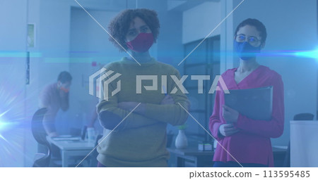 Image of glowing light trails over women in office talking and wearing face masks Image of glowing light trails over women in office talking and wearing face masks 113595485