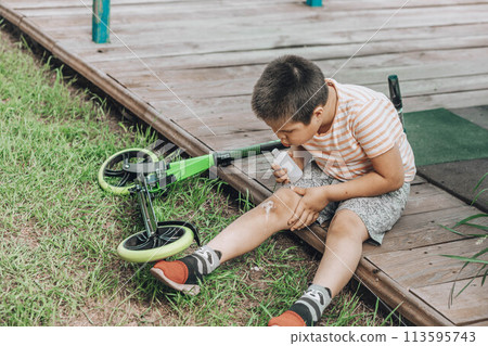 The First Bandage: A child's initiation into the world of first-aid, showing determination and care in the face of minor adversity. The First Bandage: A child's initiation into the world of first-aid, showing determination and care in the face of minor adversity. 113595743