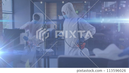 Image of glowing light trails over people disinfecting office with spray 113596026