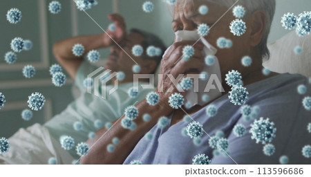 Image of covid 19 cells over senior couple in bed, woman sneezing 113596686