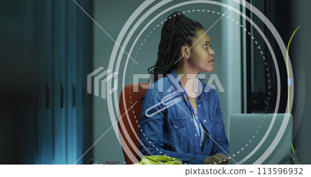 Image of clock moving over biracial woman working in servers room 113596932