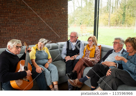 Cozy Afternoon: Seniors Enjoying Music and Company on a Comfortable Sofa Cozy Afternoon: Seniors Enjoying Music and Company on a Comfortable Sofa 113596966