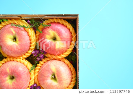 beautiful pink apple in the box on blue background beautiful pink apple in the box on blue background 113597746