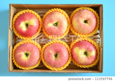 beautiful pink apple in the box on blue background beautiful pink apple in the box on blue background 113597748