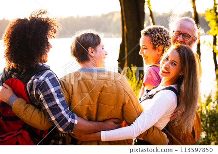 Warm Embrace: A Multigenerational Family Enjoying a Lakeside Sunset 113597850