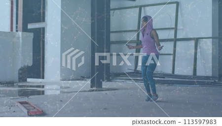 Image of network of connections over woman jumping the rope in an abandoned building 113597983
