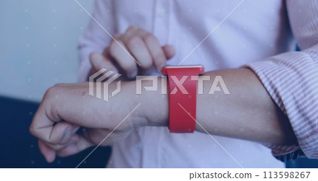 Young Caucasian man adjusts a red smartwatch on his wrist 113598267