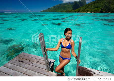 Island Bliss: Sunlight Dances on Crystal Waters as a Woman Savors Her Ocean Getaway Travel Vacation 113598574