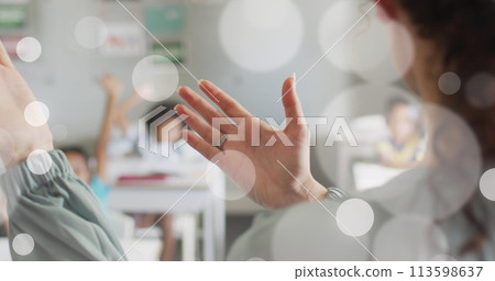 Image of white bokeh spots over hands of diverse female teacher and pupils in class Image of white bokeh spots over hands of diverse female teacher and pupils in class 113598637