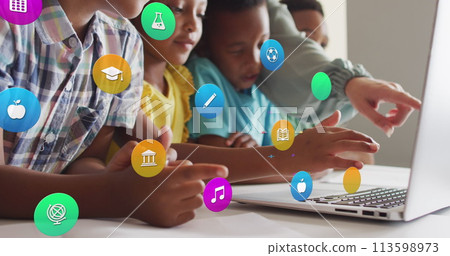 Image of school icons over diverse female teacher and pupils using laptop at desk in class 113598973