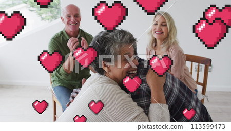 Image of hearts over diverse group of seniors embracing 113599473