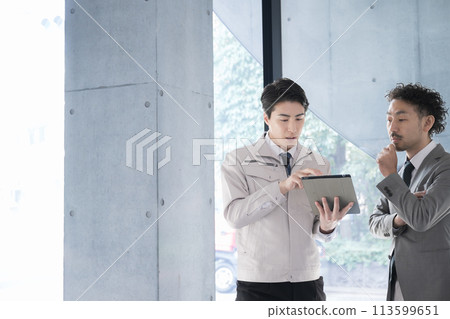 People in work clothes having a meeting looking at a tablet, businessmen who are presidents or managers, IT and DX 113599651