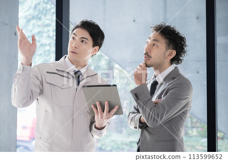 People in work clothes having a meeting looking at a tablet, businessmen who are presidents or managers, IT and DX 113599652