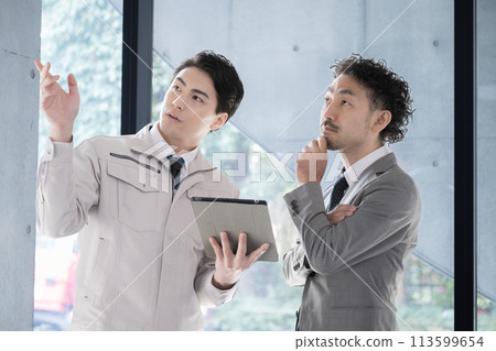 People in work clothes having a meeting looking at a tablet, businessmen who are presidents or managers, IT and DX 113599654
