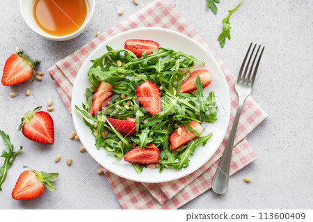 Fresh Strawberry Arugula Salad With Pine Nuts Served on a Bright Day 113600409