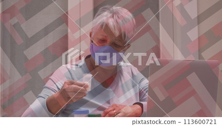 Senior biracial woman examines a medication bottle at home 113600721