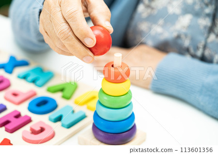 Alzheimer disease AD, Asian elderly woman patient suffering from dementia learn practical motor skills rehabilitation. Alzheimer disease AD, Asian elderly woman patient suffering from dementia learn practical motor skills rehabilitation. 113601356