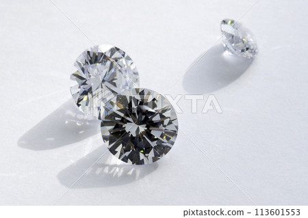 brilliant cut diamond held by tweezers on white background brilliant cut diamond held by tweezers on white background 113601553