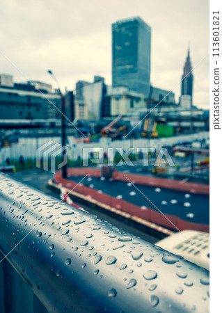 Raindrops on a pedestrian bridge Tokyo Shinjuku Station West Exit under redevelopment 2024.04 c-3 Warm colors added 113601821