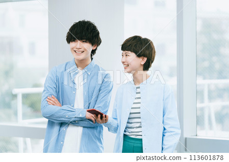 Young men and women looking at smartphones together 113601878