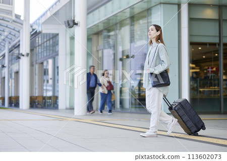 Female inbound foreign traveler traveling with a suitcase Female inbound foreign traveler traveling with a suitcase 113602073