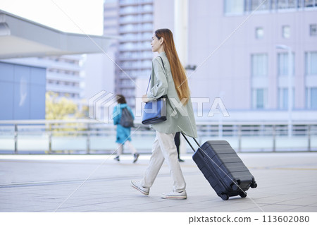 Female inbound foreign traveler traveling with a suitcase 113602080