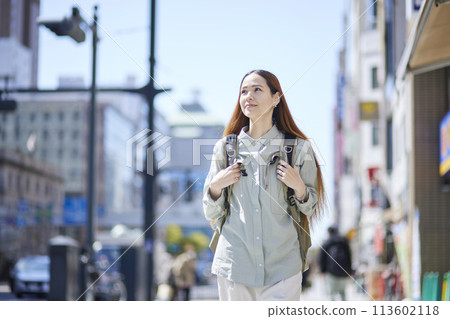 Female foreign tourist walking through the city with a backpack 113602118