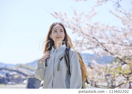 Female foreign backpacker enjoying solo travel in spring Female foreign backpacker enjoying solo travel in spring 113602202