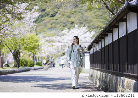 Inbound female traveler walking through a tourist spot in spring Inbound female traveler walking through a tourist spot in spring 113602211