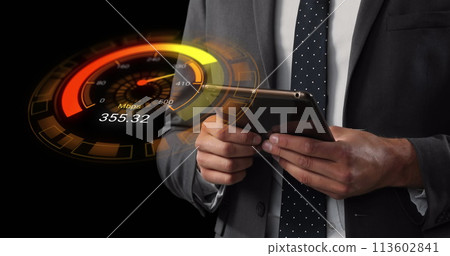 Image of orange speedometer over midsection of caucasian businessman using tablet Image of orange speedometer over midsection of caucasian businessman using tablet 113602841