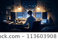 A man working on a computer at night 113603908