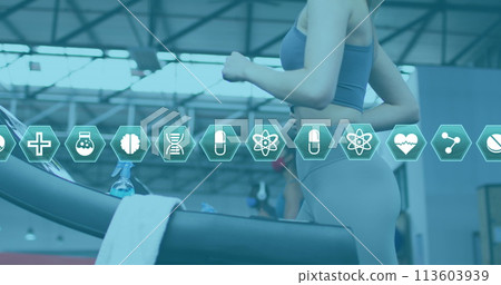 Multiple medical icons moving against woman wearing face mask running on treadmill at the gym 113603939