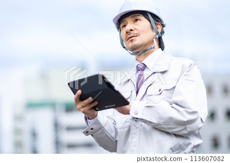 Man looking at blueprints on tablet 113607082