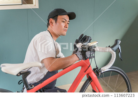 A man maintaining his road bike in his garage at home A man maintaining his road bike in his garage at home 113607223