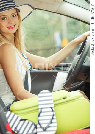 Pretty woman sit in car with suitcase 113607567