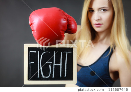 Woman wearing boxing glove holding fight sign 113607646