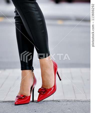 Lady with red high heel shoes and leather pants. Lady with red high heel shoes and leather pants. 113608292