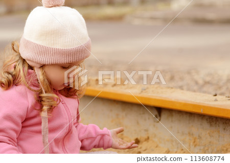Cute toddler girl playing in sand on outdoor 113608774