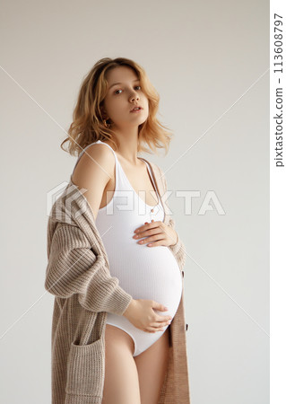 A beautiful pregnant girl in a white bodysuit and 113608797