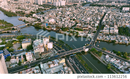 Aerial view from drone of Ho Chi Minh, big Asian city with row of crowded house, Nhieu Loc Thi Nghe canal, Y bridge cross water, vehicle traffic on road, level 4 house slum 113612256