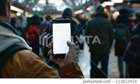 a curious tourist stands clutching a smartphone with a blank, white screen in a foreign city  a curious tourist stands clutching a smartphone with a blank, white screen in a foreign city  113612418