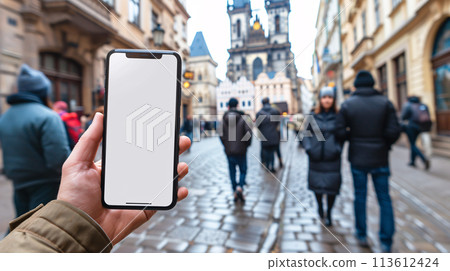 a curious tourist stands clutching a smartphone with a blank, white screen in a foreign city  a curious tourist stands clutching a smartphone with a blank, white screen in a foreign city  113612424