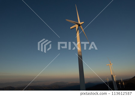 Wind power generation illuminated by the setting sun 113612587