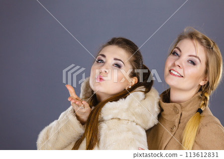 Two women wearing light brown coats Two women wearing light brown coats 113612831