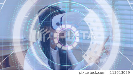 Light trails over neon scope scanner against woman gesturing while wearing vr headset at office 113613059