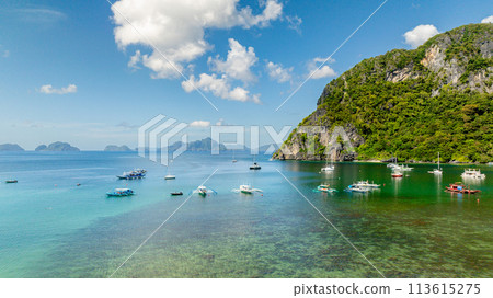 Boats over turquoise clear water with corals in shoreline. El Nido, Philippines. Boats over turquoise clear water with corals in shoreline. El Nido, Philippines. 113615275