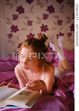 Pretty redhead Girl qith blue eyes and red hairs In White underwear Reads Book lie On pink bed Pretty redhead Girl qith blue eyes and red hairs In White underwear Reads Book lie On pink bed 113616681