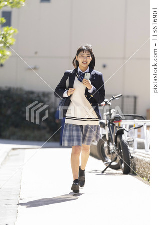 拿著智慧型手機跑步的高中女孩 113616901