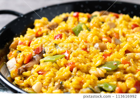 Yellow rice with chicken and vegetables on wooden table Yellow rice with chicken and vegetables on wooden table 113616992
