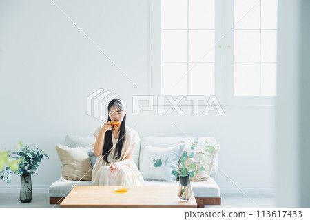 woman drinking coffee in the living room 113617433